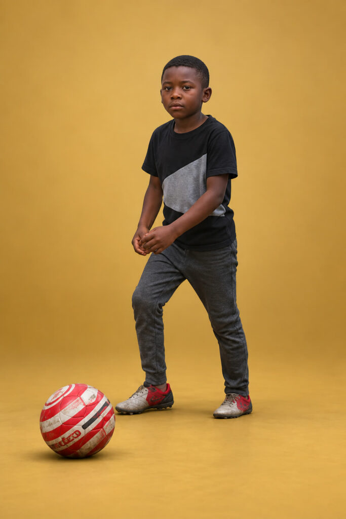 David Shelton standing beside a red and white football