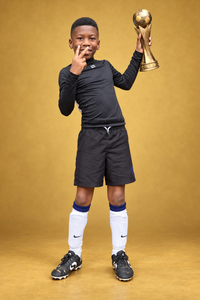 David Shelton in football kit, holding up a trophy